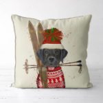 Holiday/Winter pillow featuring a black lab with a tasseled hat and a pair of skis.