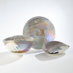 Italian glass artisans on the island of Murano form these one-of-a-kind art glass items utilizing a centrifuge process that spins molten glass in large copper bowls of various sizes.