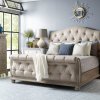 Tufted rolled footboard beige upholstered sleigh bed.