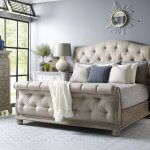 Tufted rolled footboard beige upholstered sleigh bed.