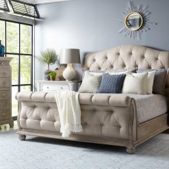 Tufted rolled footboard beige upholstered sleigh bed.