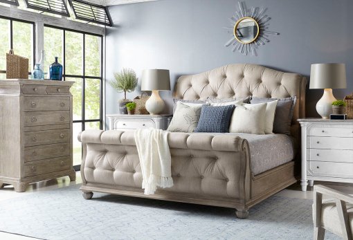 Tufted rolled footboard beige upholstered sleigh bed.