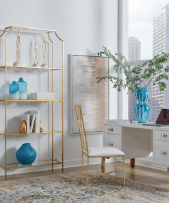 Cosby desk shown sitting in front of a city window with gold etagere.