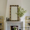 Feminine curves and fanciful scallops are highlighted in gilded gold. A lightly hand antiqued mirror finishes the overall look and makes this design a swoon-worthy addition to any space.