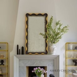 Feminine curves and fanciful scallops are highlighted in gilded gold. A lightly hand antiqued mirror finishes the overall look and makes this design a swoon-worthy addition to any space.