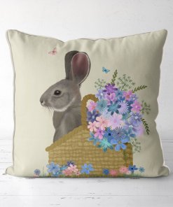 Pillow with a grey bunny sitting in a basket with pink and blue flowers.