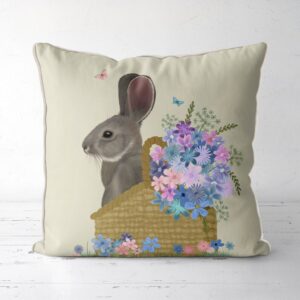 Pillow with a grey bunny sitting in a basket with pink and blue flowers.