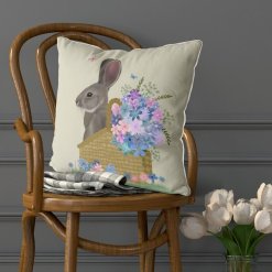 Pillow with a grey bunny sitting in a basket with pink and blue flowers. Set view.