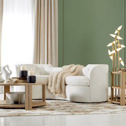 Lauren sofa in cream color, lifestyle photo. A curvaceous shape, bench seat cushion, and button-tufted detail.