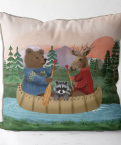 A pillow featuring hand painted art of Bear, moose and raccoon riding down the river in a canoe.