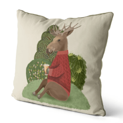 This is a pillow that features a moose design in a red sweater sitting on a hill enjoying a cup of cider.