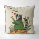 A pillow that displays a raccoon in a green sweater playing in fall leaves.