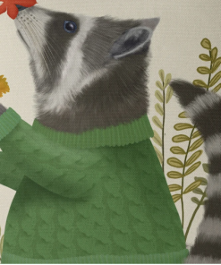 A pillow that displays a raccoon in a green sweater playing in fall leaves closeup view.