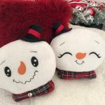 Snowman head pillow showing smiley face and sleepy face.