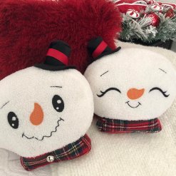 Snowman head pillow showing smiley face and sleepy face.