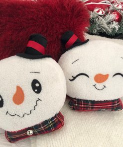 Snowman head pillow showing smiley face and sleepy face.