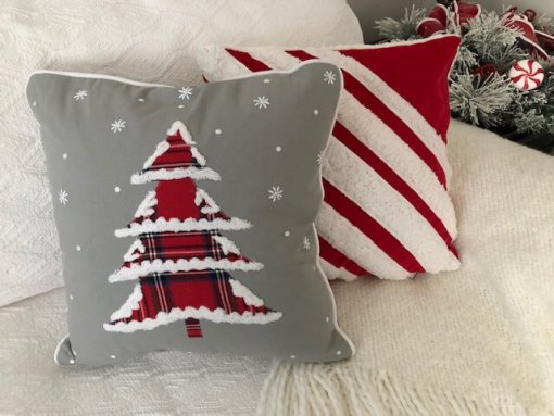 Christmas Tree with plaid fabric and snow tipped edges, on grey fabric with other pillows.