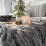 Grey ruched throw shown across end of bed.