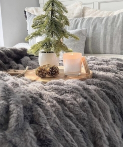 Grey ruched throw shown across end of bed.