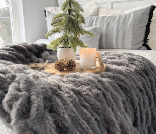 Grey ruched throw shown across end of bed.