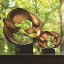 2 doves connected by their wings that forms a circle. Gold leaf finish sits on black granite base.