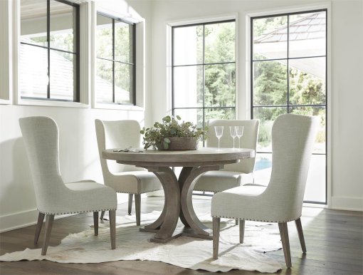 This white oak round dining table shown here with coordinating upholstered chairs.