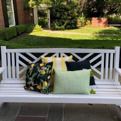 Lemons and green woven pillows shown on front porch bench