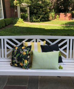 Lemons and green woven pillows shown on front porch bench