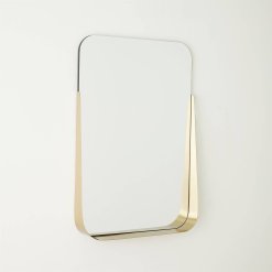 Rectangular mirror with brushed brass shelf angled.